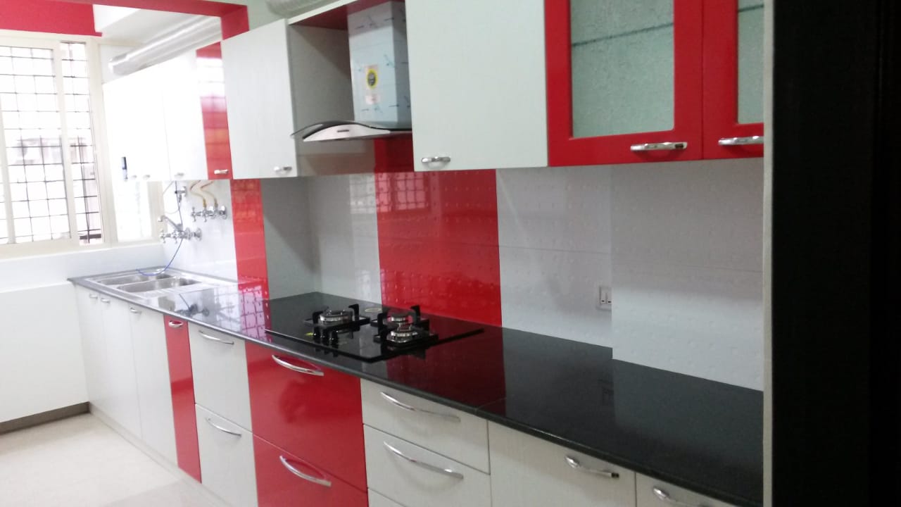 Red and white modular kitchen with hob and chimney